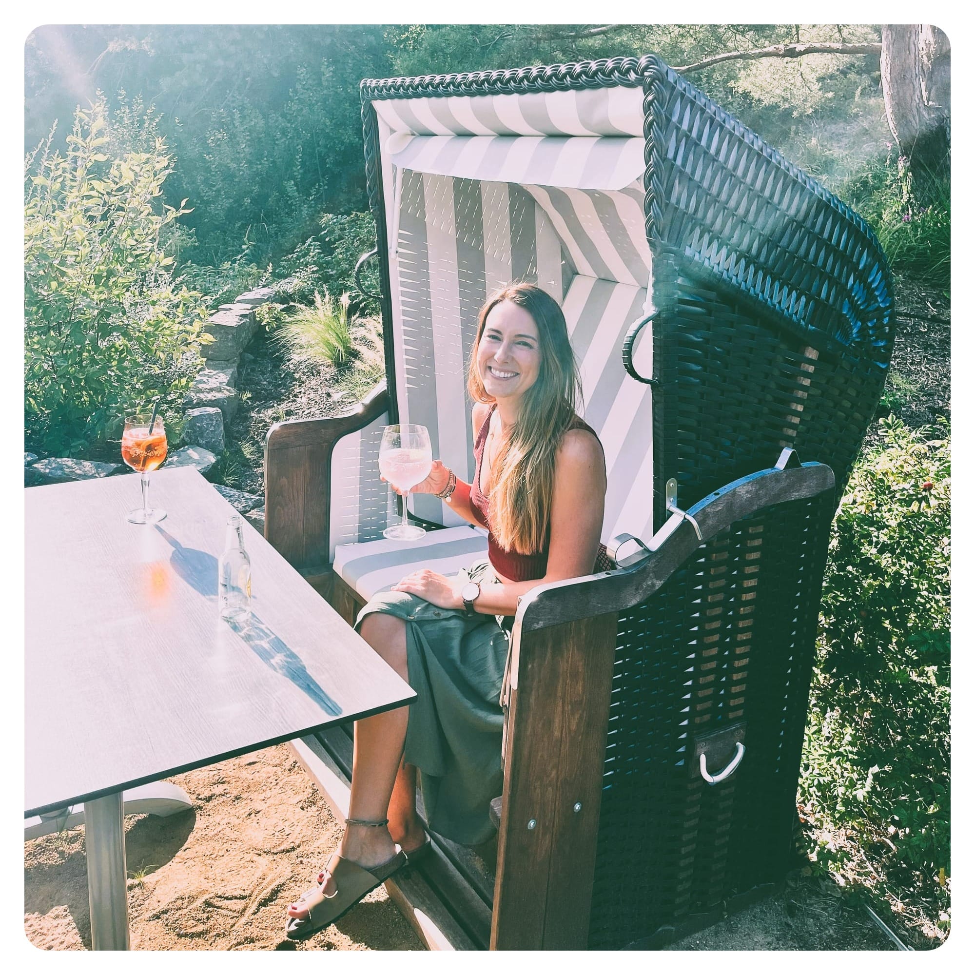 vanlavita woman enjoying drink and sitting in a beach basket in sunny garden at Dune 74 restaurant
